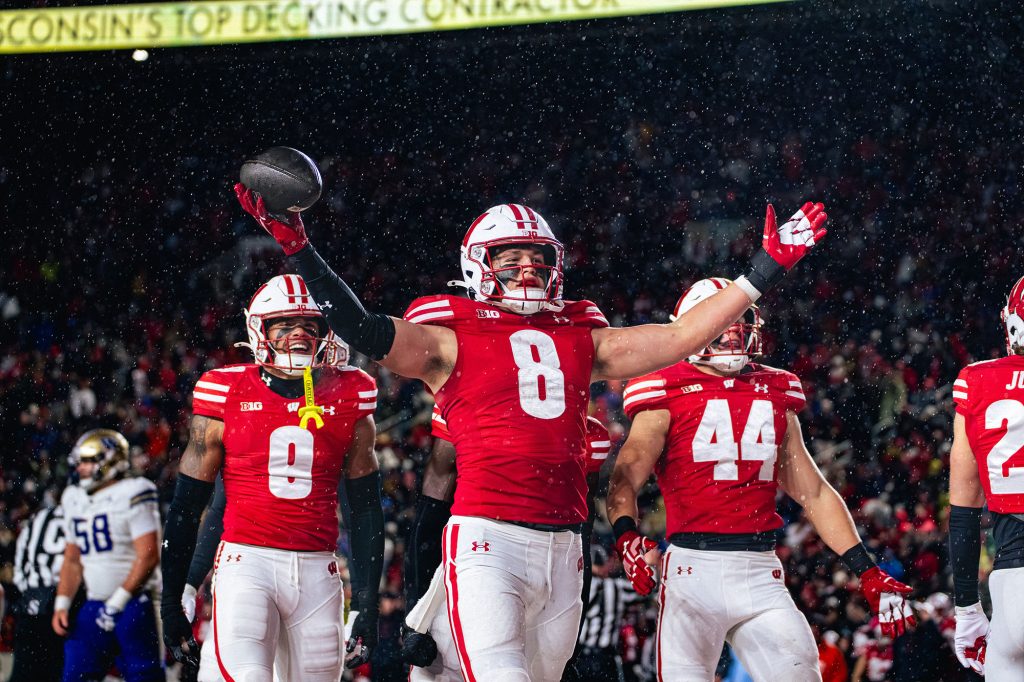 Badger football quarterback Deuce Adams celebrates with teammates after a play