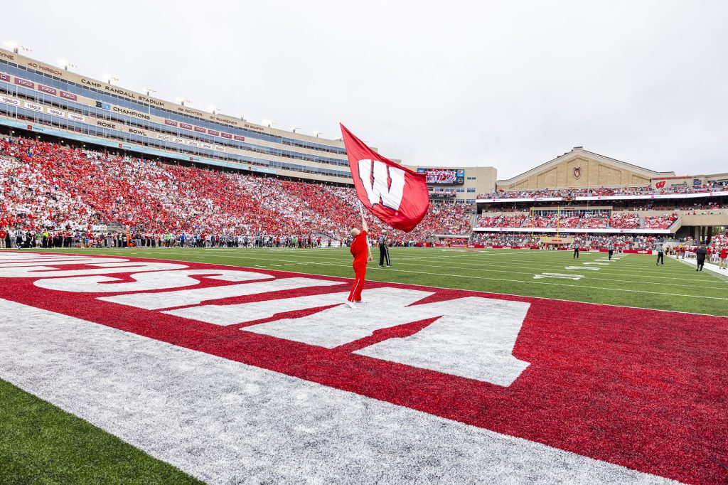 A member of the cheer team waves a "W" flag in the end zone of Camp Randall Stadium during a Badger football game