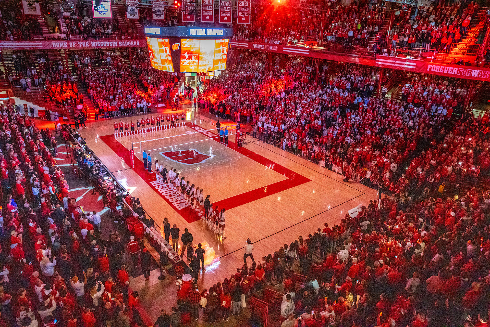 Women's volleyball players line up on the court before a game at the UW Field House