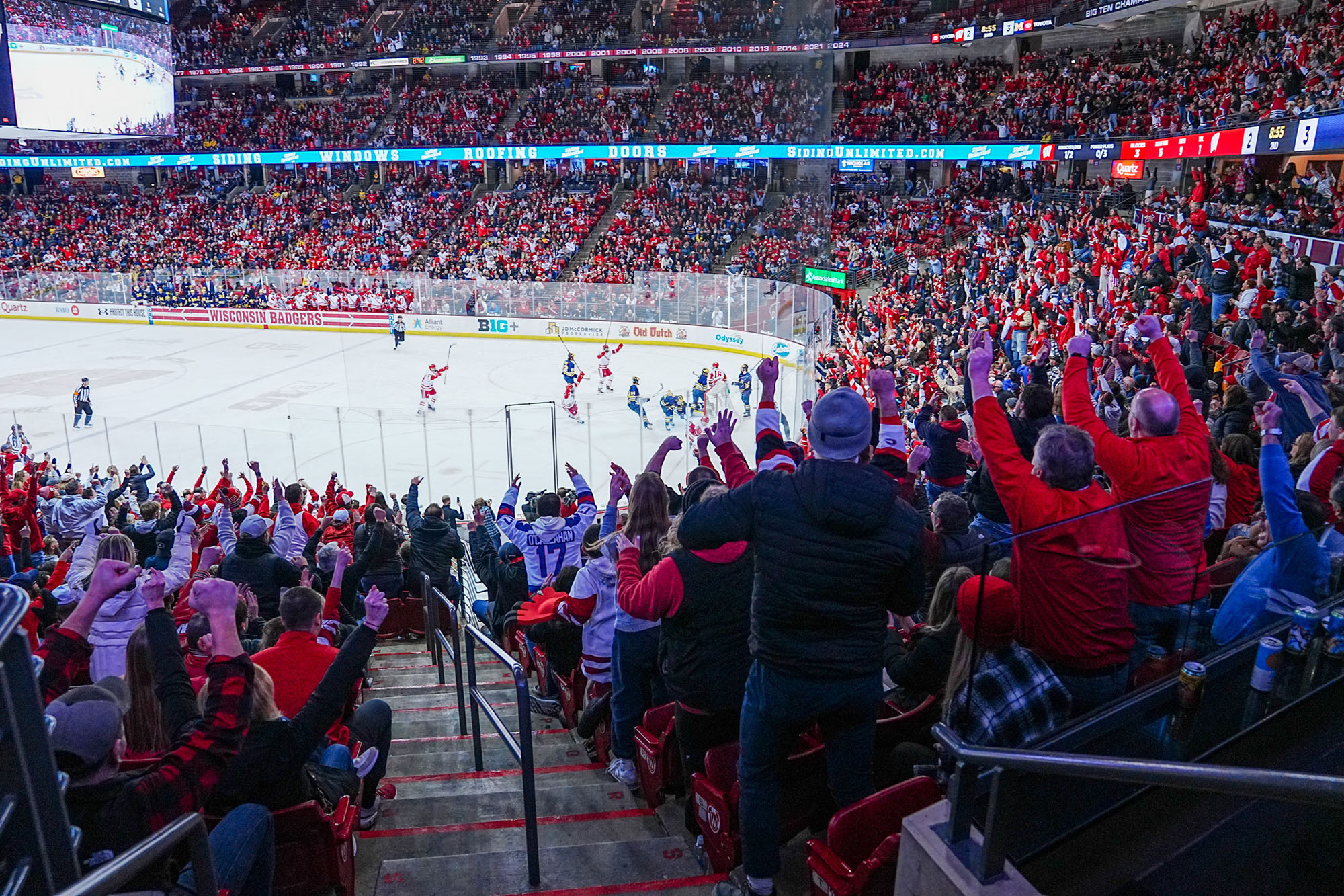 Hockey fans cheer on the UW team on the Kohl Center ice rink